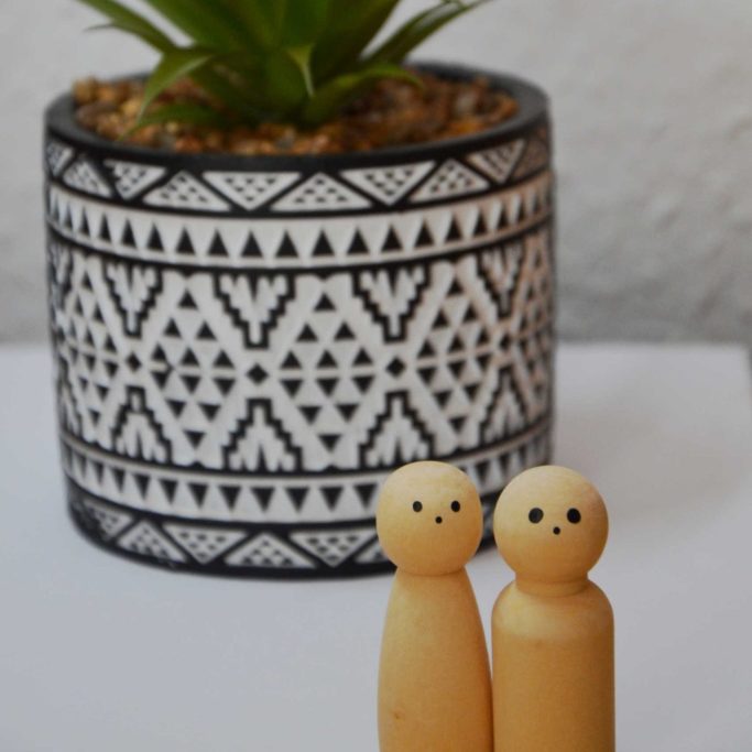 Systembrett-Symbolfoto – Psychotherapie & EMDR Saarburg Zwei Holzfiguren als Symbol für therapeutische Beziehung vor grüner Pflanze – Psychotherapie & EMDR-Traumatherapie in Saarburg, Trier.